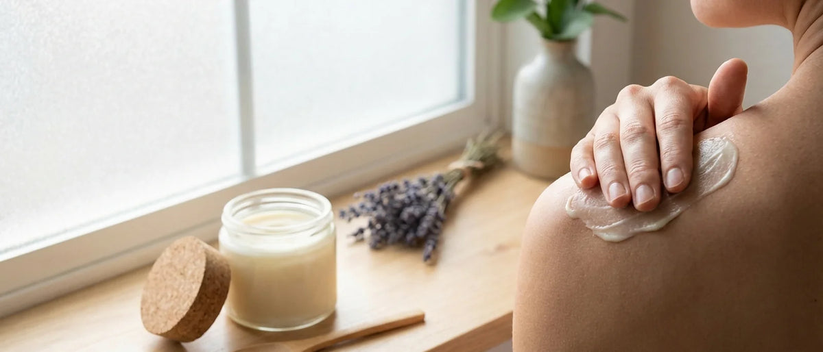Person applying natural CBD salve to shoulder muscle showing self-care wellness routine