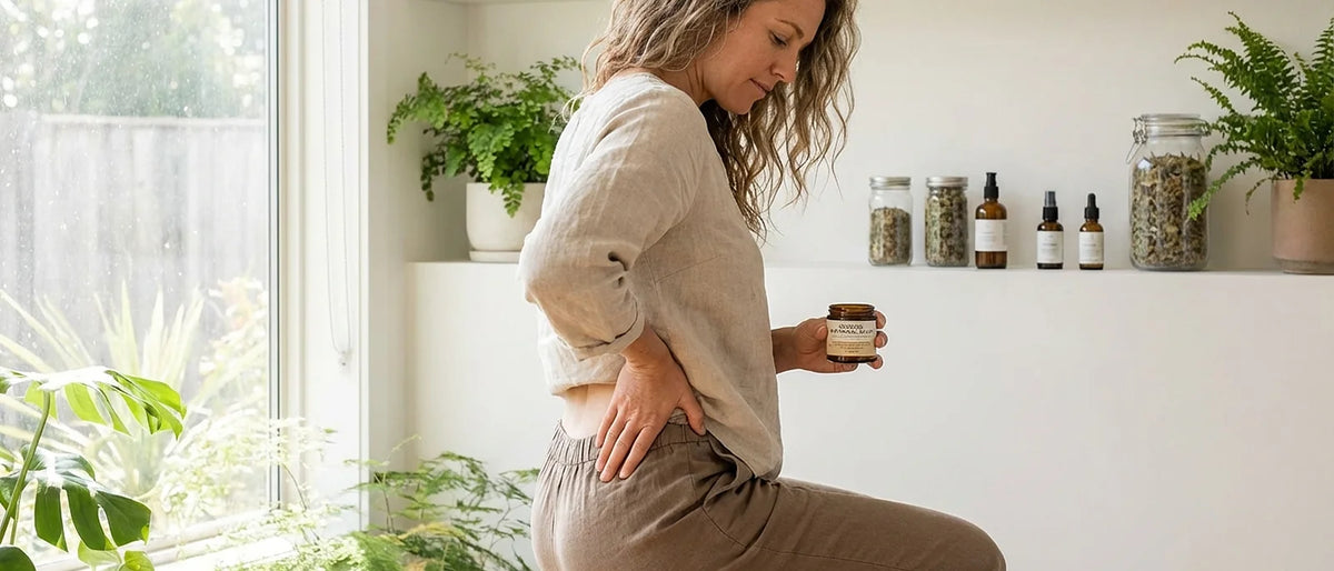 Person applying natural cooling salve to lower back for sciatica pain relief in peaceful wellness setting
